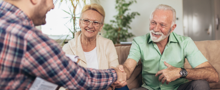 Positive aged couple consulting with insurance agent