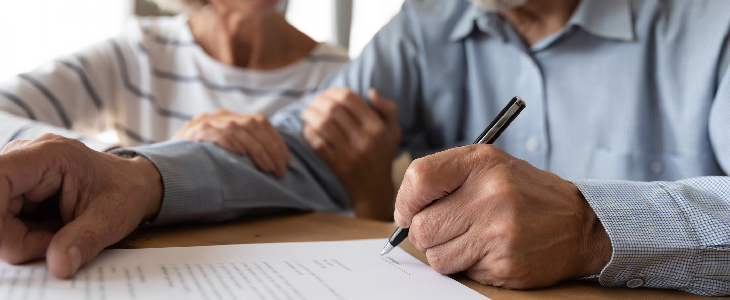 Elderly couple signing legal document