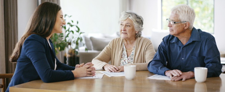 Elderly couple discussing legal matters with an attorney.