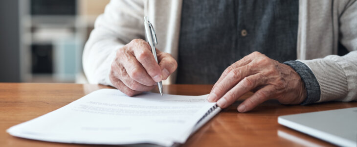 person who is writing on an estate planning document